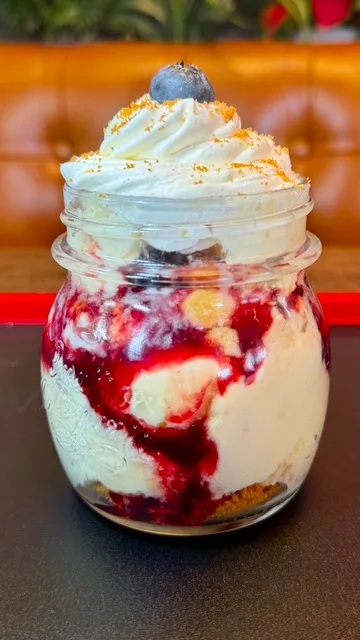 Lemon tres leche cake, fresh blueberries, blackberry coulis, crushed biscoff cookies, whipped cream