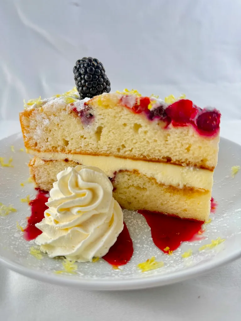 Spongy lemon cake, berries, and whipped cream